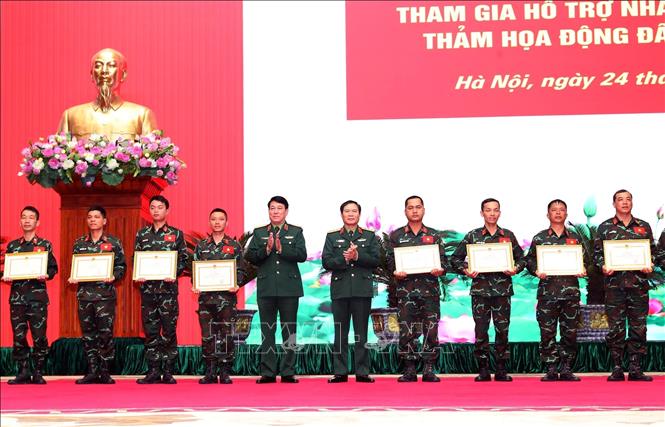 Sen. Lieut. Gen. Nguyen Tan Cuong, Chief of the General Staff of the VPA and Deputy Minister of National Defence, and General Luong Cuong present certificates of merit from Minister of National Defence to officers and soldiers at the ceremony. VNA Photo: Trọng Đức