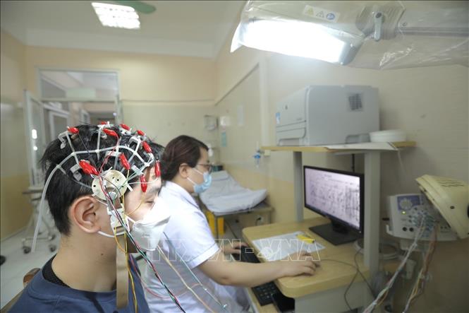 Nhân viên y tế làm điện não đồ cho bệnh nhân. Ảnh: Minh Quyết - TTXVN