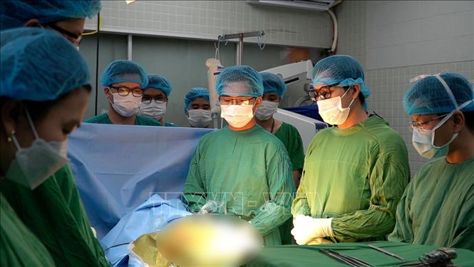 Trong ảnh: Các y bác sĩ Bệnh viện Chợ Rẫy dành một phút mặc niệm trước khi tiếp nhận tạng. Ảnh: TTXVN phát
