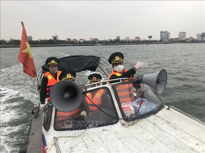 Cán bộ, chiến sĩ Bộ đội Biên phòng Quảng Bình chủ động, tích cực tuyên truyền tới ngư dân về tình hình dịch bệnh COVID-19. Ảnh: Đức Thọ - TTXVN
