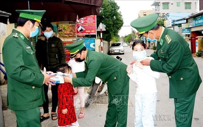Chiến sĩ Bộ đội Biên phòng Quảng Bình hướng dẫn trẻ em trên địa bàn đeo khẩu trang để phòng, chống dịch COVID-19. Ảnh: TTXVN phát.