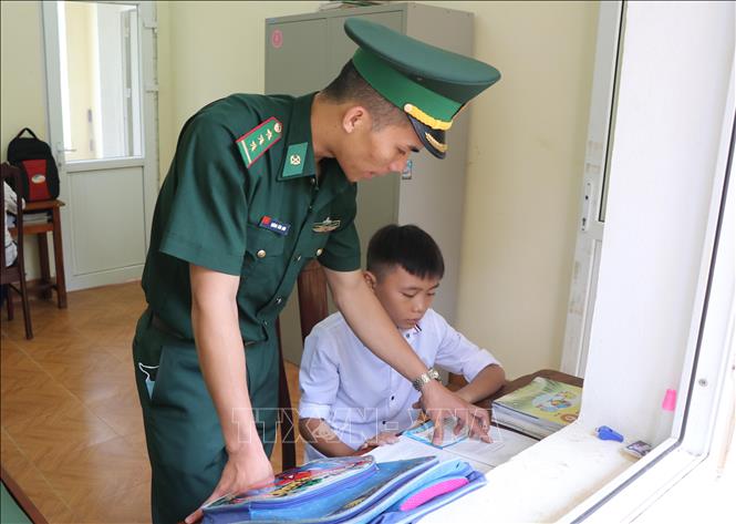 Chiến sĩ Đồn Biên phòng Pa Thơm (BĐBP tỉnh Điện Biên) kèm cặp, hỗ trợ các cháu con nuôi của đơn vị học tập hằng ngày. Ảnh: Xuân Tiến - TTXVN