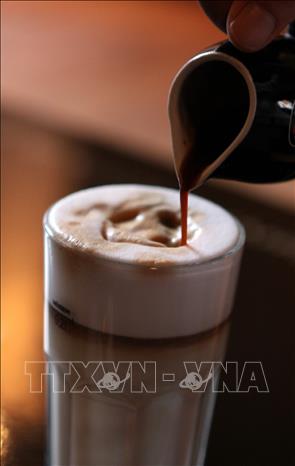 Traditional Vietnamese coffee can also be enjoyed in novel ways: milk and ice are mixed together first, then strong brewed coffee is poured over the mixture. VNA Photo: Phạm Hậu