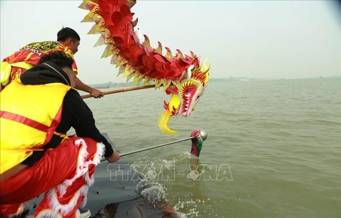 Nghi thức lấy nước sông Hồng để rước về đền Đa Hòa. Ảnh: Mai Ngoan - TTXVN


