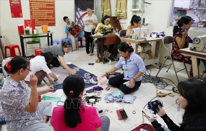 Chị em phụ nữ thuộc Hội Liên hiệp Phụ nữ Phường 1, Quận 4 (TP HCM) may khẩu trang tặng người nghèo. Ảnh: Đinh Hằng - TTXVN