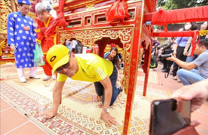 Người dân bò qua gầm kiệu 3 lần để cầu may mắn và sức khỏe. Ảnh: Tuấn Đức - TTXVN