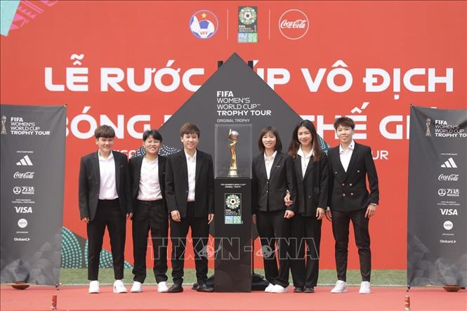 Các cầu thủ Đội tuyển bóng đá nữ Việt Nam chụp ảnh bên chiếc Cúp vô địch Bóng đá nữ thế giới. Ảnh: Minh Quyết - TTXVN