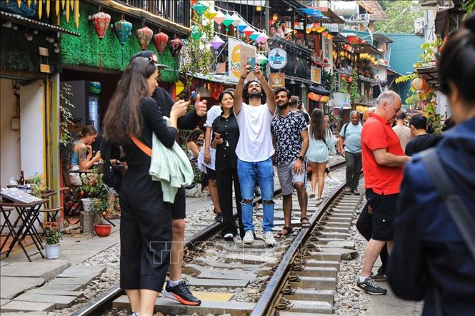 Du khách nước ngoài tụ tập rất đông để trải nghiệm chụp ảnh ngay trên đường tàu (ảnh chụp chiều 4/3/2023). Ảnh: Tuấn Anh - TTXVN