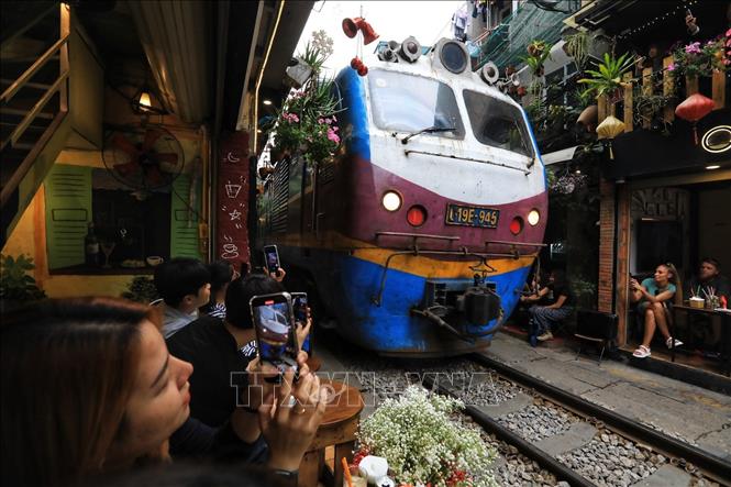 Trải nghiệm ngồi uống cafe mỗi khi có tàu đi qua đều mang lại cảm giác thích thú của du khách (ảnh chụp chiều 4/3). Ảnh: Tuấn Anh - TTXVN