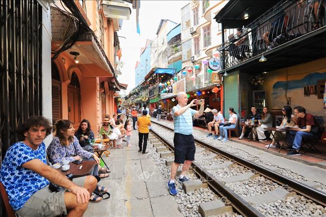 Du khách nước ngoài thích thú ghi lại những bức ảnh kỷ niệm ngay trên đường tàu (ảnh chụp chiều 4/3). Ảnh: Tuấn Anh - TTXVN