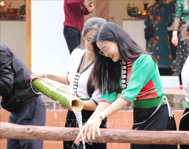 Du khách rửa tay bên mó nước nơi Nàng Han tắm gội sau khi đánh thắng giặc trước khi bay về trời để cầu may. Ảnh: Nguyễn Oanh-TTXVN.