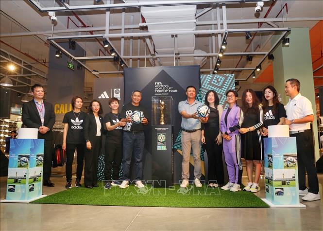 Các đại biểu chụp ảnh cùng Cúp vô địch Bóng đá nữ thế giới. Ảnh: Tuấn Đức - TTXVN