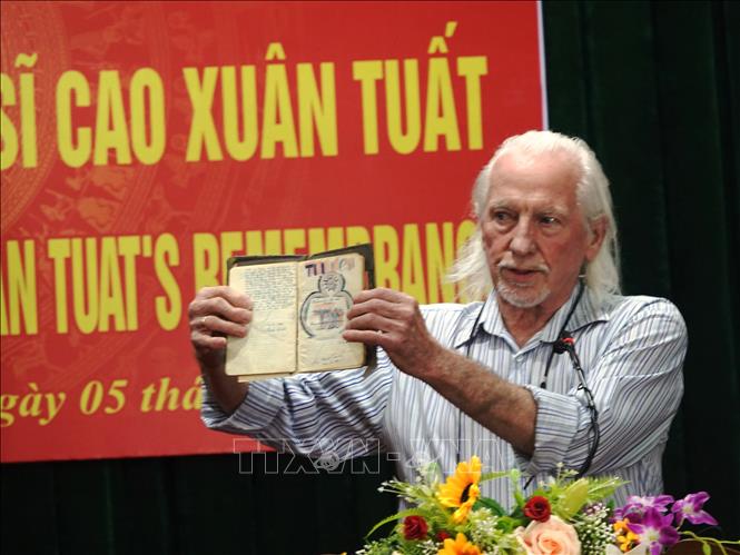 Trong ảnh: Cựu binh Mỹ Peter Mathews và cuốn nhật ký của Liệt sỹ Cao Xuân Tuất trước khi trao lại cho thân nhân của liệt sỹ. Ảnh: Phan Quân - TTXVN