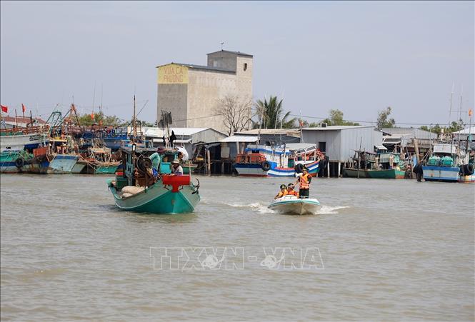 Trong ảnh: Cán bộ Trạm kiểm soán Biên phòng Rạch Gốc kiểm tra tàu cá trên vùng cửa biển Cà Mau. Ảnh: Hồng Đạt - TTXVN
