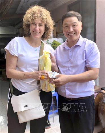 Foreign visitors come and purchase the handmade fish sauce of Nam O village. VNA Photo: Quốc Dũng
