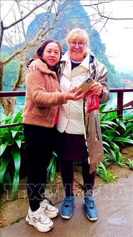 Chị Nguyễn Thị Cương (trái) thợ nhiếp ảnh thuộc Đội ảnh Trung tâm Du lịch Phong Nha - Kẻ Bàng đã từng nhặt được tài sản của du khách để quên. Ảnh: TTXVN phát