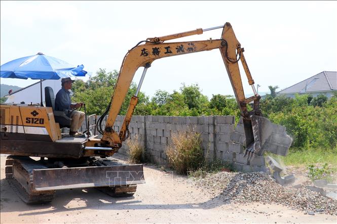 Trong ảnh: Tháo dỡ hàng rào khu biệt thự xây dựng vi phạm trên đất rừng phòng hộ. Ảnh: Lê Huy Hải - TTXVN