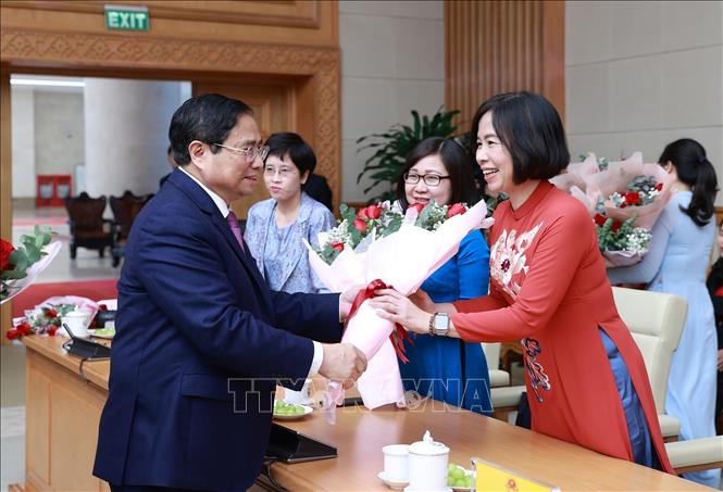 Thủ tướng Phạm Minh Chính tặng hoa chúc mừng Tổng giám đốc TTXVN Vũ Việt Trang và Phó TGĐ TTXVN Đoàn Thị Tuyết Nhung. Ảnh: Dương Giang-TTXVN
