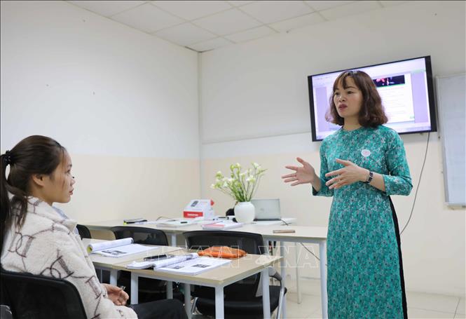 Nữ giảng viên trường Đại học Nguyễn Trãi (Hà Nội) lên lớp trong trang phục áo dài truyền thống đúng ngày 8/3. Ảnh: Thanh Tùng - TTXVN