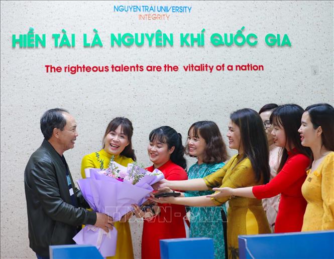 TS. Nguyễn Tiến Luận, Hiệu trưởng trường Đại học Nguyễn Trãi (Hà Nội) tặng hoa chúc mừng các nữ giảng viên nhân ngày 8/3. Ảnh: Thanh Tùng - TTXVN 