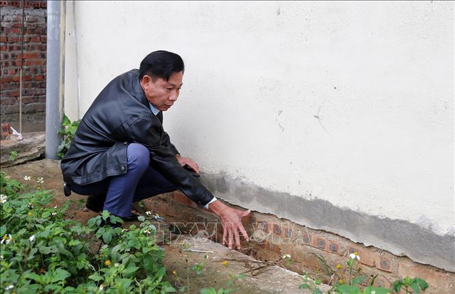 Trong ảnh: Thầy giáo Trần Duy Hưng, Hiệu trưởng trường THCS số 1 Phố Ràng, kiểm tra vị trí sụt lún chân tường dãy nhà học 2 tầng. Ảnh: Quốc Khánh - TTXVN