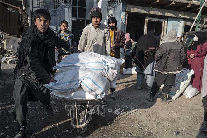 Người dân vận chuyển thực phẩm viện trợ tại Kabul, Afghanistan. Ảnh: AFP/ TTXVN