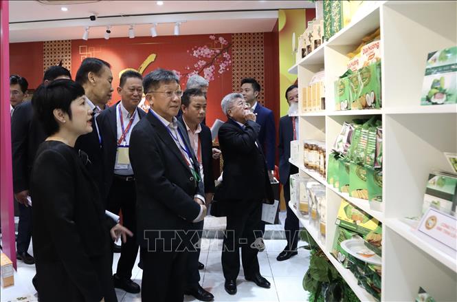 Singaporean businesses visit a booth introducing Vietnamese goods opened on the sidelines of the conference. VNA Photo: Xuân Anh