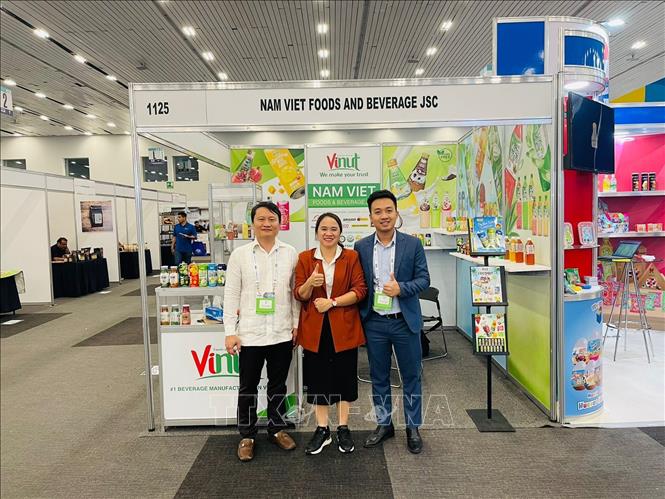 Trong ảnh: Đại diện Thương vụ Việt Nam tại Mexico hỗ trợ doanh nghiệp trong việc giới thiệu và quảng bá gian hàng của VINUT tại Hội chợ. Ảnh: TTXVN phát