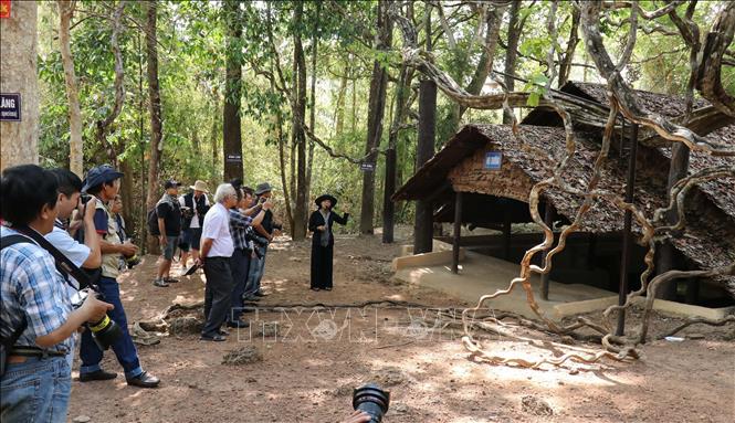 Trong ảnh: Nhân viên khu di tích căn cứ Tà Thiết giới thiệu với du khách hội trường, nơi diễn ra các cuộc họp của Bộ Chỉ huy Miền Nam. Ảnh: Sỹ Tuyên - TTXVN