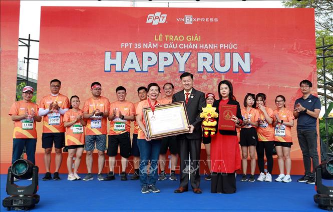 Đại diện Hội Kỷ lục gia Việt Nam - Tổ chức Kỷ lục Việt Nam Vietkings trao quyết định xác nhận kỷ lục Việt Nam cho màn đồng diễn điệu nhảy “Kiến tạo Hạnh phúc” cho đại diện Tập đoàn FPT tại chương trình. Ảnh: Trần Lê Lâm – TTXVN 