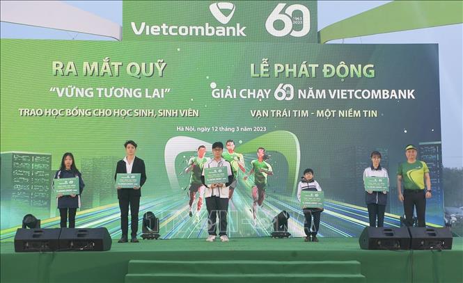 Ông Nguyễn Thanh Tùng, Thành viên Hội đồng quản trị, Tổng Giám đốc Vietcombank (ngoài cùng bên phải) trao học bổng cho học sinh nghèo vượt khó, tài năng. Ảnh: Trần Việt - TTXVN 