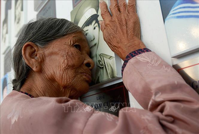 Bà Hà Thị Liên (quê Can Lộc, Hà Tĩnh), mẹ liệt sĩ Đào Kim Cương, hôn lên di ảnh con trai ở khu lưu niệm di vật liệt sĩ Gạc Ma trong khu tưởng niệm chiến sĩ Gạc Ma. Ảnh: TTXVN phát