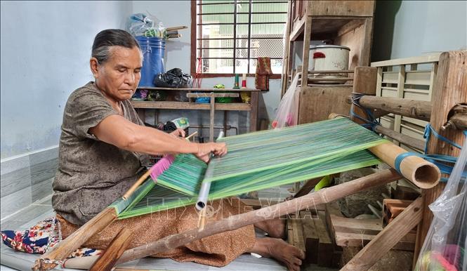 Trong ảnh: Nghệ nhân lớn tuổi người Chăm dệt vải thổ cẩm truyền thống. Ảnh: Nguyễn Thành – TTXVN