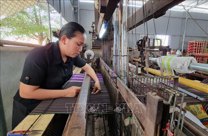 Trong ảnh: Chị La Ha Ta Ma Ri ở làng Mỹ Nghiệp (thị trấn Phước Dân, huyện Ninh Phước) đầu tư máy dệt để nâng cao hiệu quả sản xuất. Ảnh: Nguyễn Thành – TTXVN