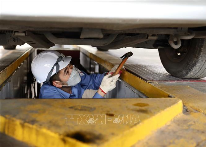 Nhân viên đăng kiểm Trung Tâm đăng kiểm xe cơ giới 2906V (Tam Hiệp, Thanh Trì) kiểm tra gầm của xe. Ảnh: Hoàng Hiếu - TTXVN