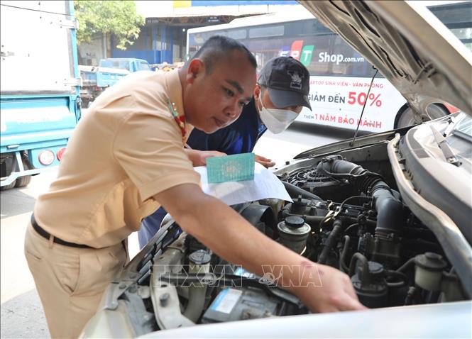 Đại úy công an Đinh Văn Toàn (PC08 Hưng Yên ) kiểm tra số khung số máy của xe đến đăng kiểm tại Trung Tâm đăng kiểm xe cơ giới 2906V (Tam Hiệp, Thanh Trì, Hà Nội). Ảnh: Hoàng Hiếu - TTXVN