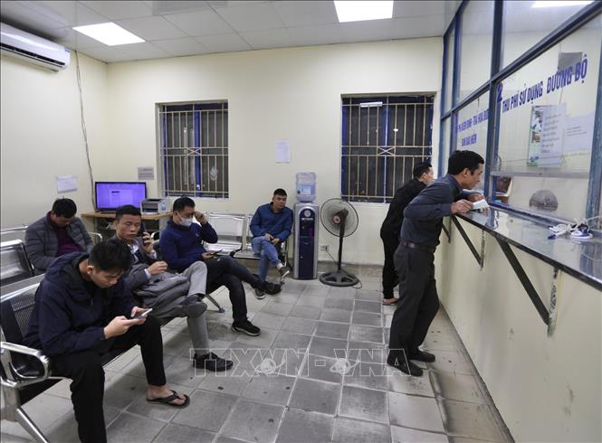 Nhiều chủ xe, lái xe chờ đến lượt kiểm tra xe tại Trung Tâm đăng kiểm xe cơ giới 2906V (Tam Hiệp, Thanh Trì, Hà Nội) sáng 14/3. Ảnh: Hoàng Hiếu - TTXVN