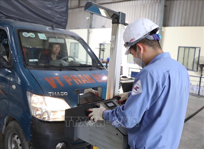 Nhân viên đăng kiểm Trung Tâm đăng kiểm xe cơ giới 2906V (Tam Hiệp, Thanh Trì, Hà Nội) kiểm tra hệ thống chiếu sáng của xe. Ảnh: Hoàng Hiếu - TTXVN