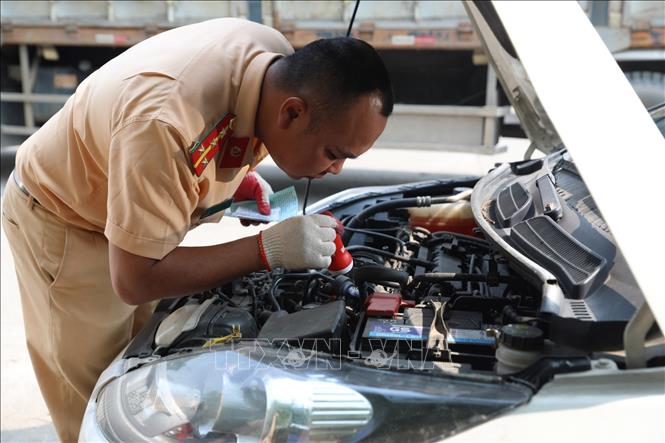 Đại úy công an Đinh Văn Toàn (PC08 Hưng Yên ) kiểm tra số máy của xe đến đăng kiểm sáng 14/3. Ảnh: Hoàng Hiếu - TTXVN