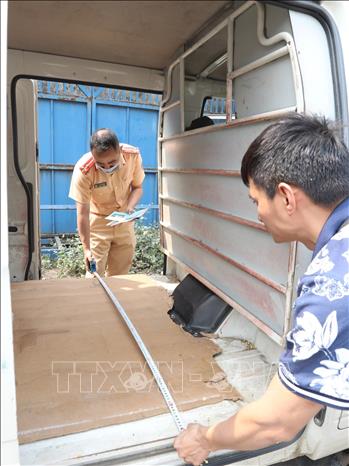 Đại úy công an Tô Anh Dũng (PC08 Nghệ An) kiểm tra xe đến đăng kiểm tại Trung Tâm đăng kiểm xe cơ giới 2906V (Tam Hiệp, Thanh Trì, Hà Nội)  sáng 14/3. Ảnh: Hoàng Hiếu - TTXVN