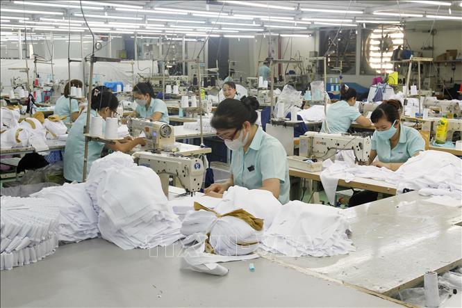 Trong ảnh: Công nhân Công ty TNHH Ampfield trong giờ làm việc luân phiên, giảm giờ làm. Ảnh: Thanh Vũ - TTXVN
