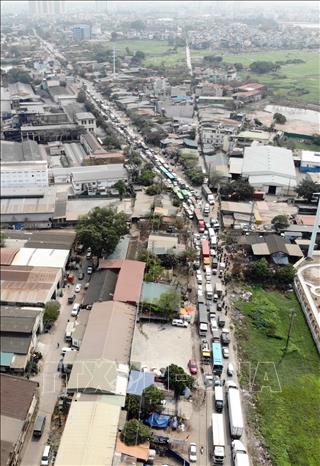 Dòng xe xếp hàng bên ngoài Trung Tâm đăng kiểm xe cơ giới 2906V (Tam Hiệp, Thanh Trì, Hà Nội) trưa 14/3 khiến đường 70 đã tắc lại càng tắc. Ảnh: Hoàng Hiếu - TTXVN