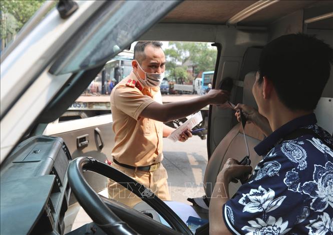 Đại úy công an Tô Anh Dũng (PC08 Nghệ An) kiểm tra hệ thống đai an toàn của xe đến đăng kiểm tại Trung Tâm đăng kiểm xe cơ giới 2906V (Tam Hiệp, Thanh Trì, Hà Nội). Ảnh: Hoàng Hiếu - TTXVN