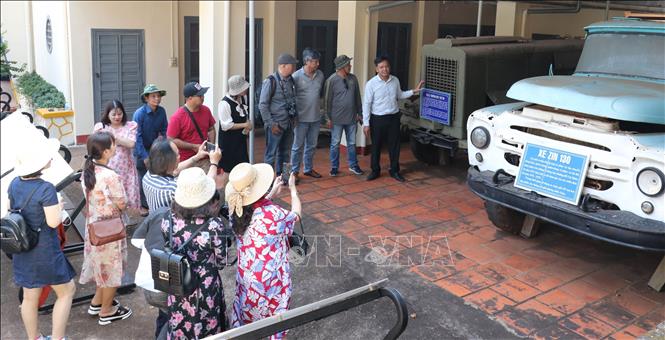 Trong ảnh: Nhân viên Ban quản lý di tích Nhà Giao tế giới thiệu cho du khách về máy bơm nhiên liệu dùng để bơm xăng dầu qua đường ống dẫn chạy dọc Trường Sơn chi viện cho chiến trường miền Nam. Ảnh: Sỹ Tuyên - TTXVN