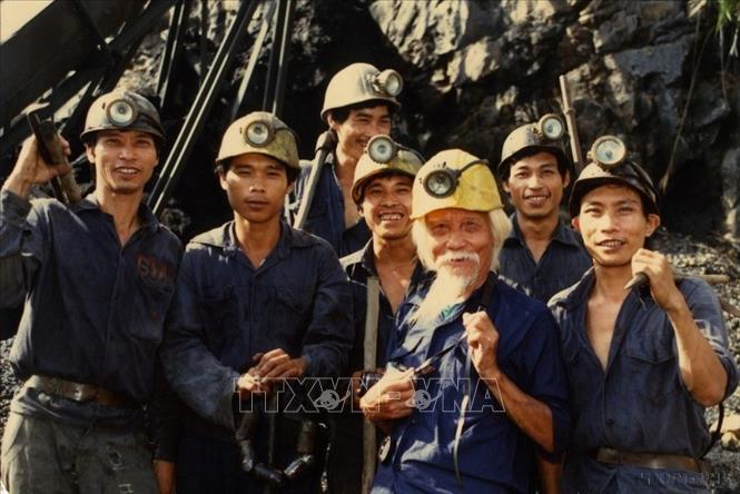 Nghệ sĩ nhiếp ảnh Võ An Ninh (đội mũ vàng) chụp ảnh chung với công nhân khai thác mỏ than Quảng Ninh trong những năm chống chiến tranh phá hoại của Mỹ ở miền Bắc. Ảnh: Minh Lộc - TTXVN