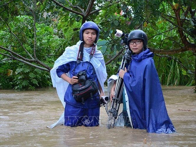Các phóng viên Trịnh Xuân Tư (trái) và Võ Văn Dũng (TTXVN) tác nghiệp trong trận mưa lũ gây ngập lụt cục bộ tại TP. Điện Biên Phủ năm 2018. Ảnh: TTXVN