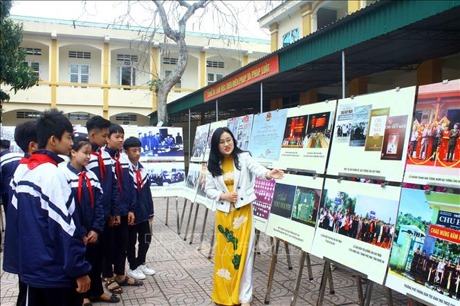 Các em học sinh Trường Trung học cơ sở Hưng Hòa (thành phố Vinh, tỉnh Nghệ An) tham quan triển lãm ảnh tìm hiểu thân thế sự nghiệp của Đại tướng Chu Huy Mân. Ảnh: Tá Chuyên - TTXVN