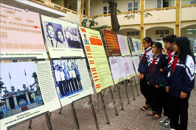 Các em học sinh Trường Trung học cơ sở Hưng Hòa (thành phố Vinh, tỉnh Nghệ An) tham quan triển lãm ảnh tìm hiểu thân thế sự nghiệp của Đại tướng Chu Huy Mân. Ảnh: Tá Chuyên - TTXVN