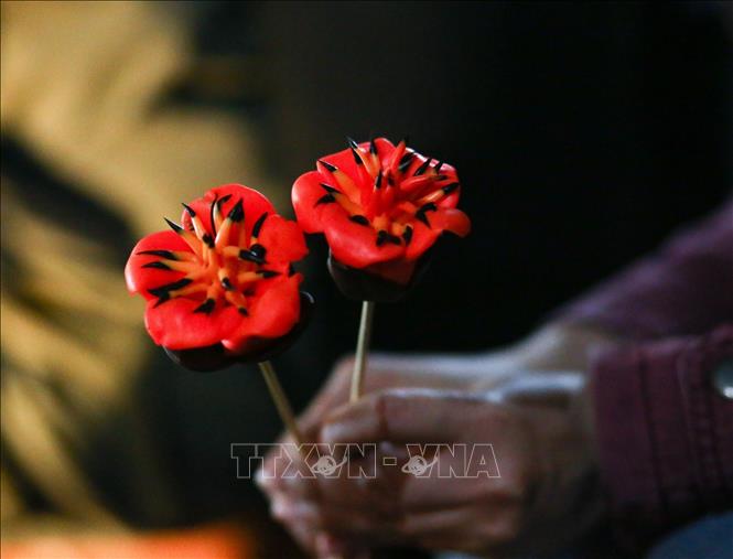 To he - a traditional clay toy in rural Vietnam - in the shape of the giant bombax ceiba tree's red flowers. VNA Photo: Tuấn Đức
