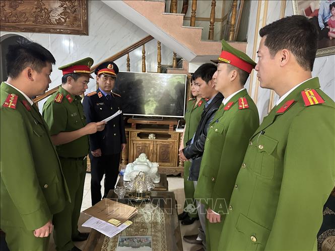 Trong ảnh: Lực lượng chức năng đọc lệnh bắt giam giam Lê Văn Khang. Ảnh: Trịnh Duy Hưng - TTXVN
